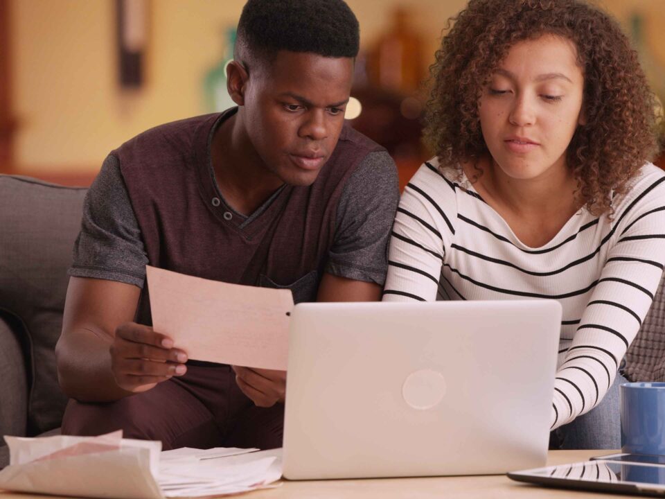 couple pays their bills on their laptop